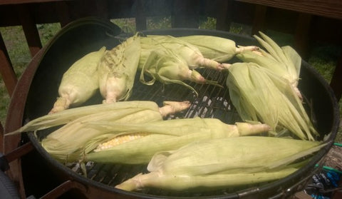 Corn situated on the grill, tops pointed outward.