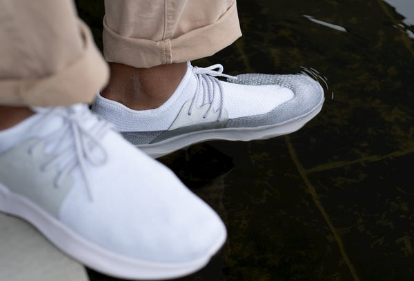 Man wearing Vessi rain shoes immersing his foot in the water
