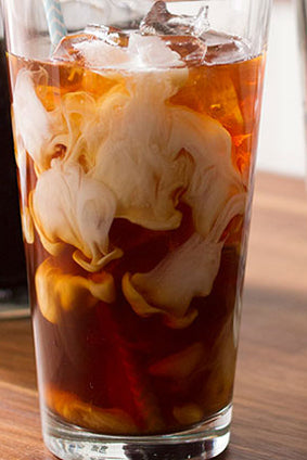 brewed iced tea with cream swirls in clear glass