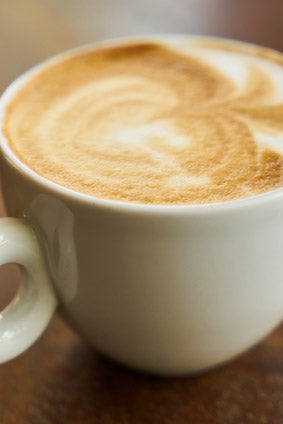 cappuccino in white cup on wooden table