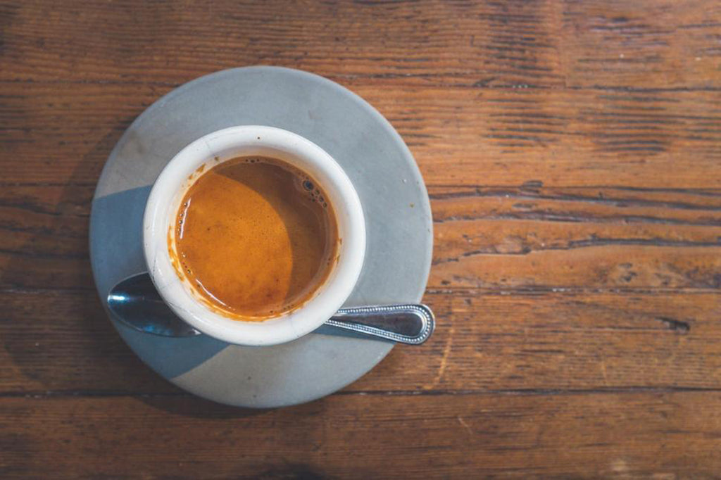 espresso in blue cup on wooden table