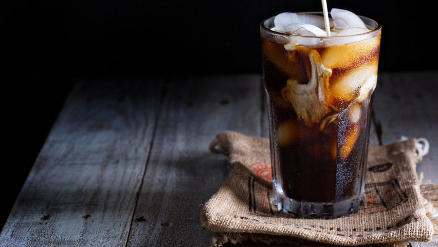 iced coffee in clear glass on small coffee bag