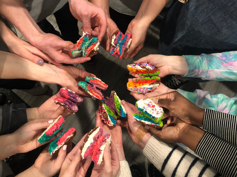 Image of people holding rainbow cookies