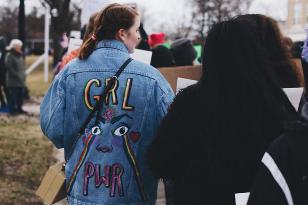 Woman wearing recycled denim jacket embroidered with Girl Power