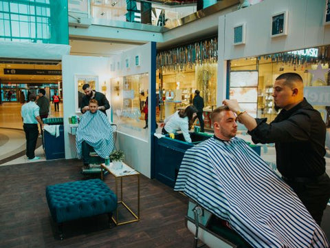 Claudio Ferreira and Joshua Dos Santos cut hair at the Toronto Eaton Centre for Heineken's 0.0 premium non-alcoholic beer barbershop booth