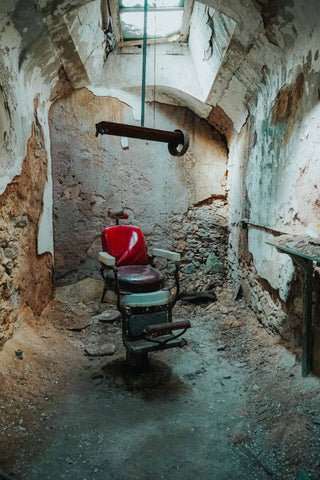 worlds most famous barber chair, abandoned barber chair inside of jail cell in the eastern state penitentiary in philadelphia