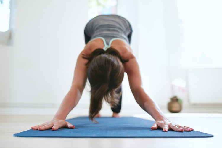 Une femme fait des étirements sur un tapis de gym après son Hatha Yoga