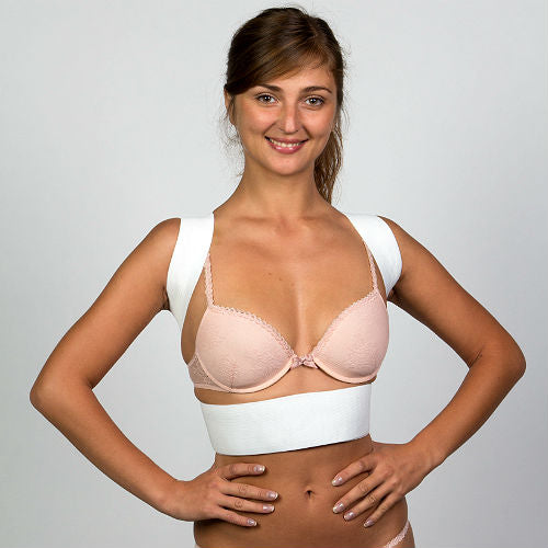 Une femme porte un corset correcteur de posture magnétique noir pour soulager ses problèmes de dos : scoliose, cyphose, stenose.