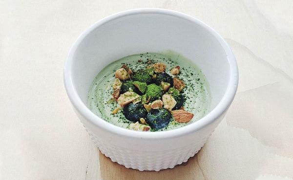 A green smoothie bowl with probiotic matcha green tea sprinkled on top.