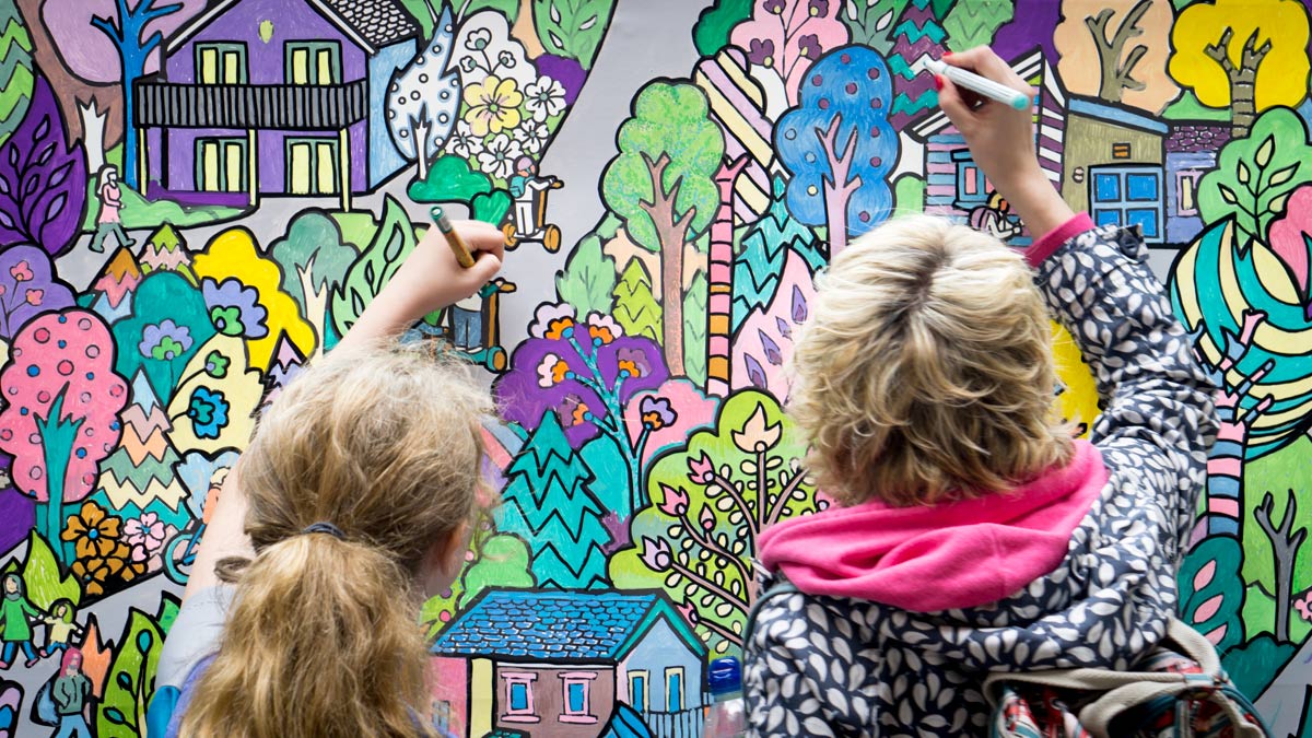 family painting a giant colouring wall