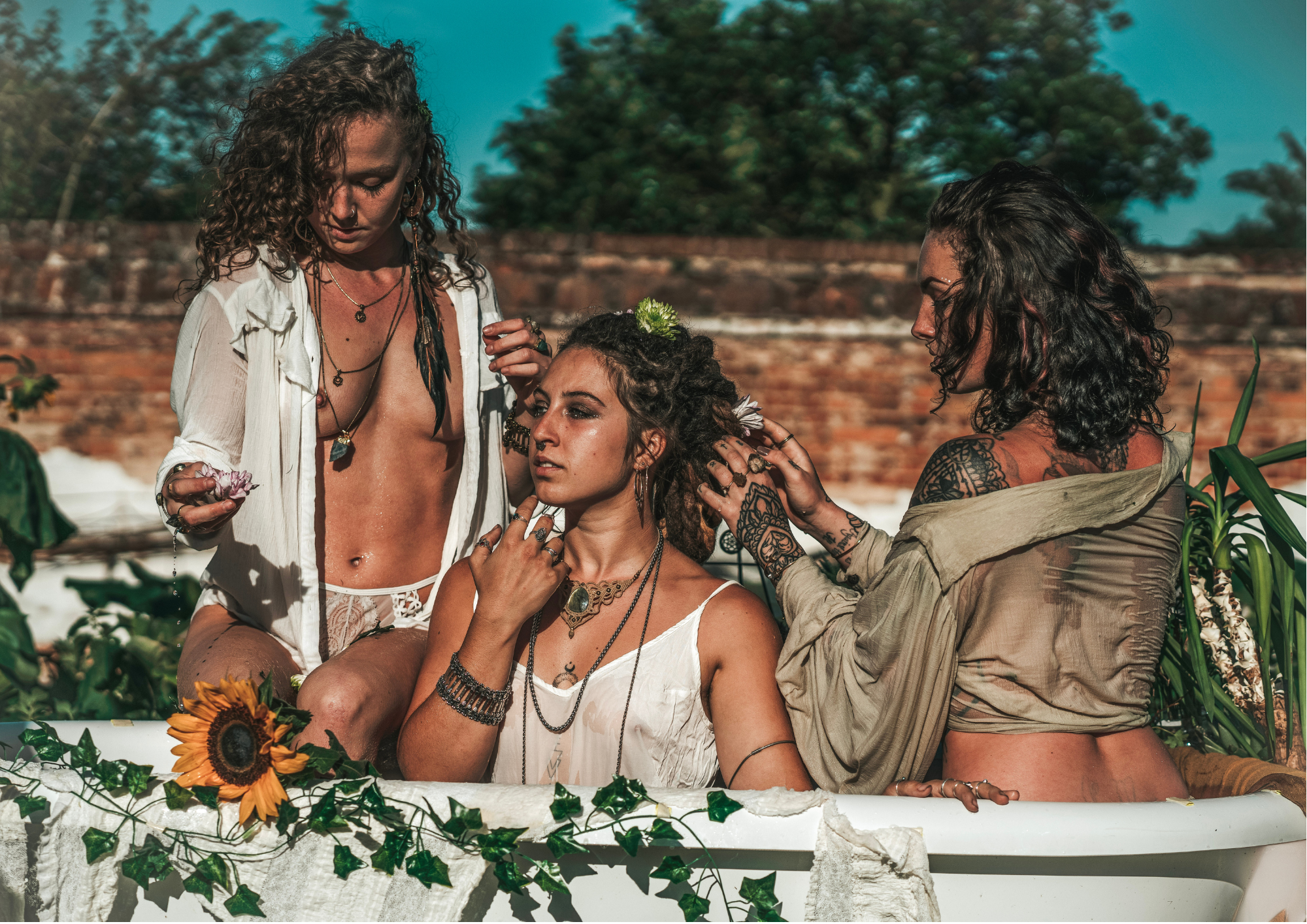 three women in bath with flowers and bohemian jewellery, natural fashion, ethical brand, goddess fashion, wild woman 