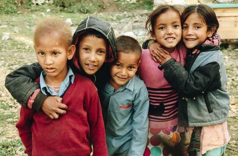 Children in a group smiling. Goods for Good send valuable items to refugees, displaced communities and vulnerble people around the world. 