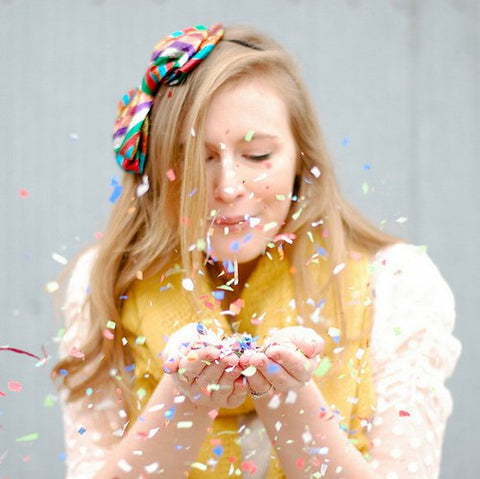girl blowing confetti
