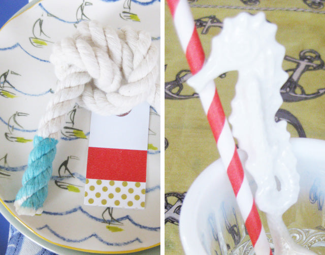 cheery yellow silk anchor scarf as a table runner, dishes in blues and whites, dip-dyed tip of nautical rope stripey straw and a seahorse spoon