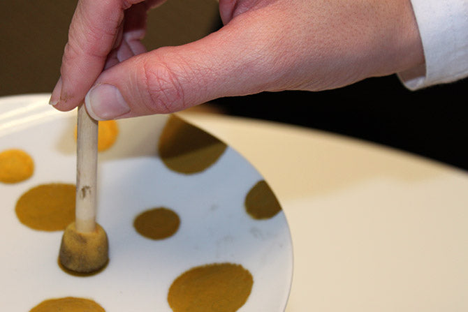 painting a plate with a sponge brush