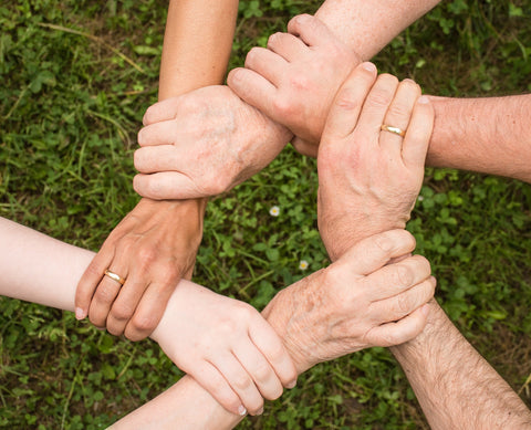 hands in a circle as a team of essential tremor sufferers