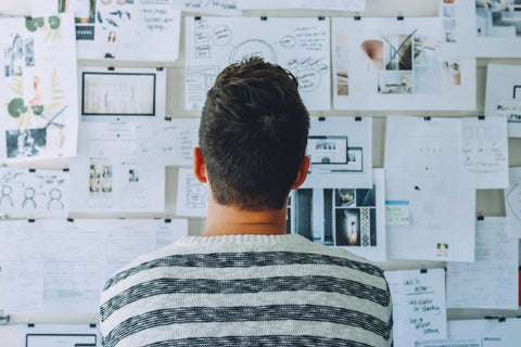 Man looking at wall of notes, organizing