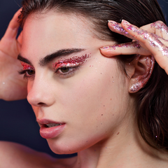 Stunning woman with dark hair wearing pink glitter on her eyelids