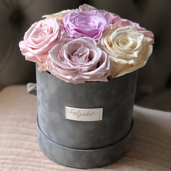 Colorful preserved roses in grey round velvet box