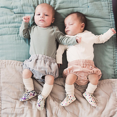 newborn twins in Amy and Ivor lace up baby shoes spots and flower prints uk baby fashion coco and wolf baby bloomers camomile london baby quilts