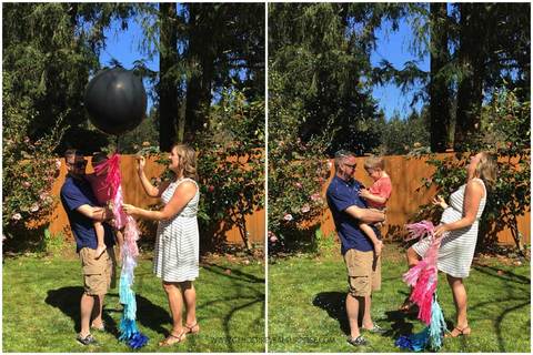 Couple posing with a gender reveal balloon.
