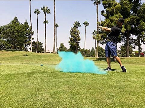 Individual hitting a blue smoke filled golf ball, announcing them having a baby boy