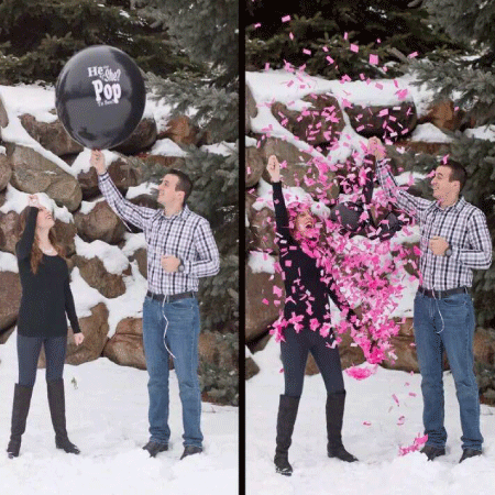 A couple posed outside during winter with a pink confetti filled balloon