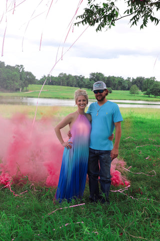 Couple outside posing with pink smoke.