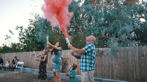 Family shooting a pink smoke cannon to announce their daughter.