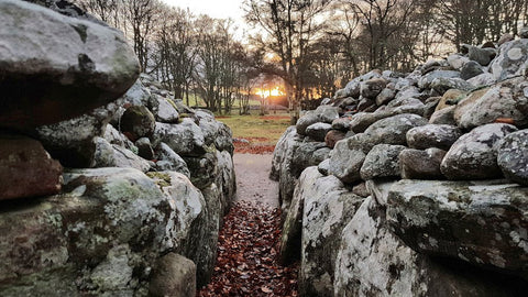 Sun aligning with clava cairns ancient pagan celtic stones at the winter solstice
