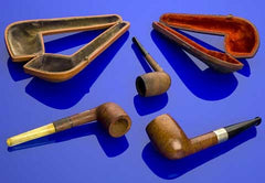 Still life of smoking pipes and pipe cases on blue background