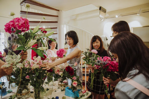 Participants selecting flowers and arranging them together into an elegantly designed flower bouquet.