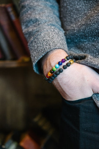 Man with hand in pocket, wearing healing chakra bracelets