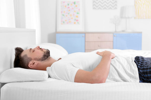 man sleeping with pillow on back