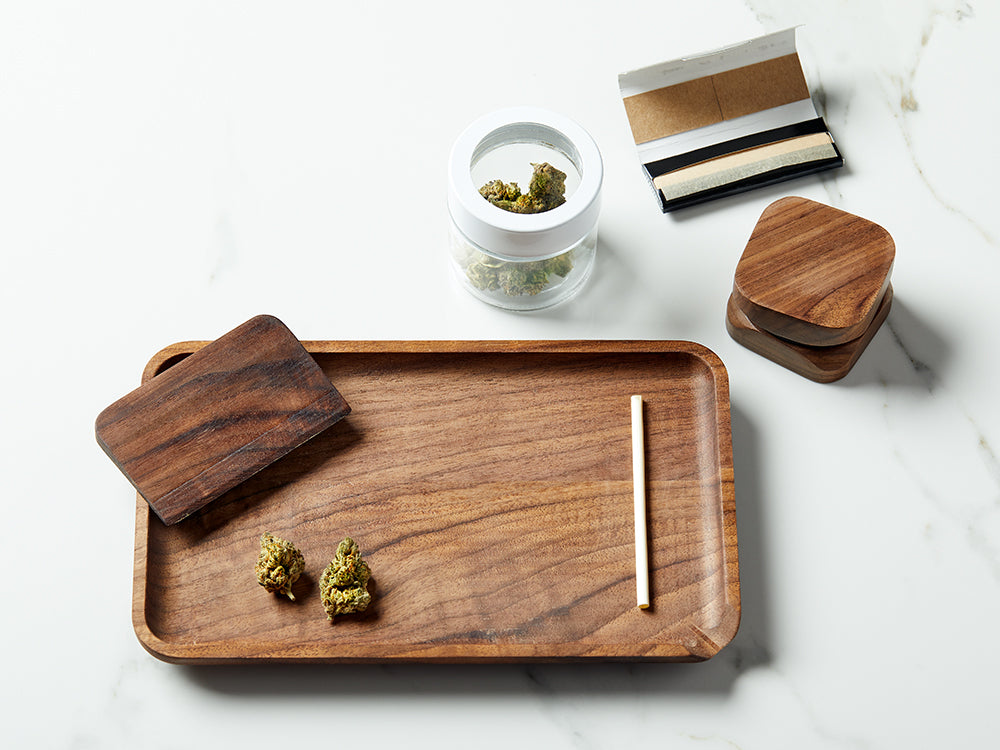 Image of a rolling tray and rolling accessories with dried cannabis 