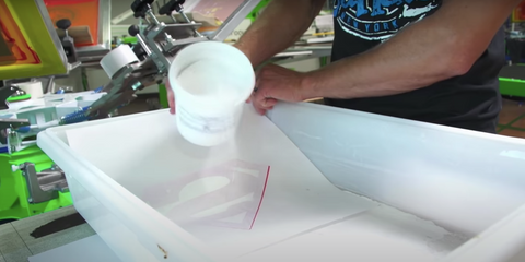 person pouring adhesion powder on transfer