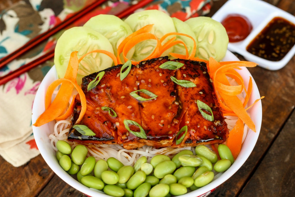 Asian Style Salmon Noodle Bowl is a quick and easy dinner idea with sockeye salmon marinated and pan seared over rice noodles with edamame, carrots, and cucumbers.