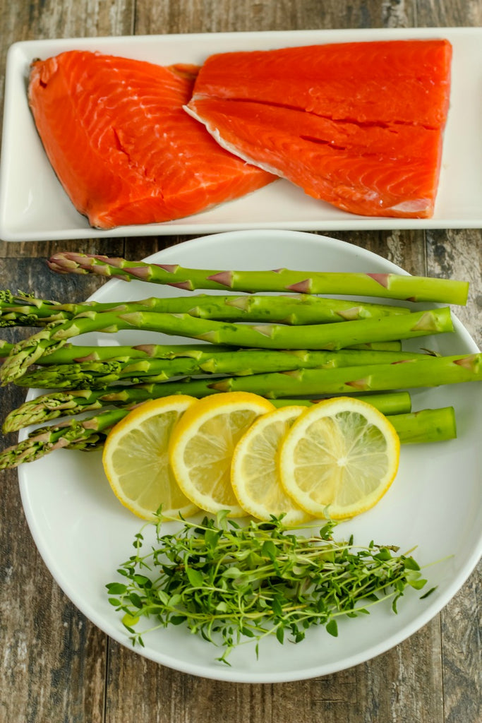 Salmon and Asparagus in Parchment ~ Sockeye Salmon delicately seasoned with salt and pepper upon stalks of crisp asparagus, topped with lemon slices and fresh thyme, sealed in parchment paper for a succulently easy and elegant dinner option. 