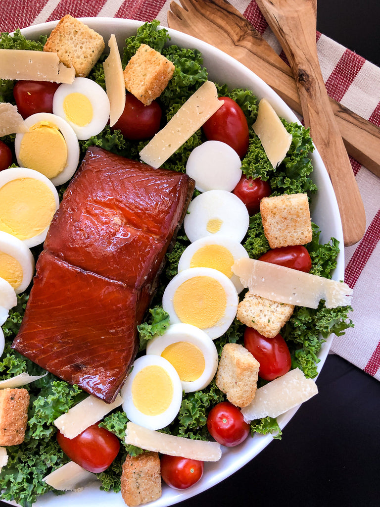 Side view with whole portion of smoked salmon with all the salad ingredients. 