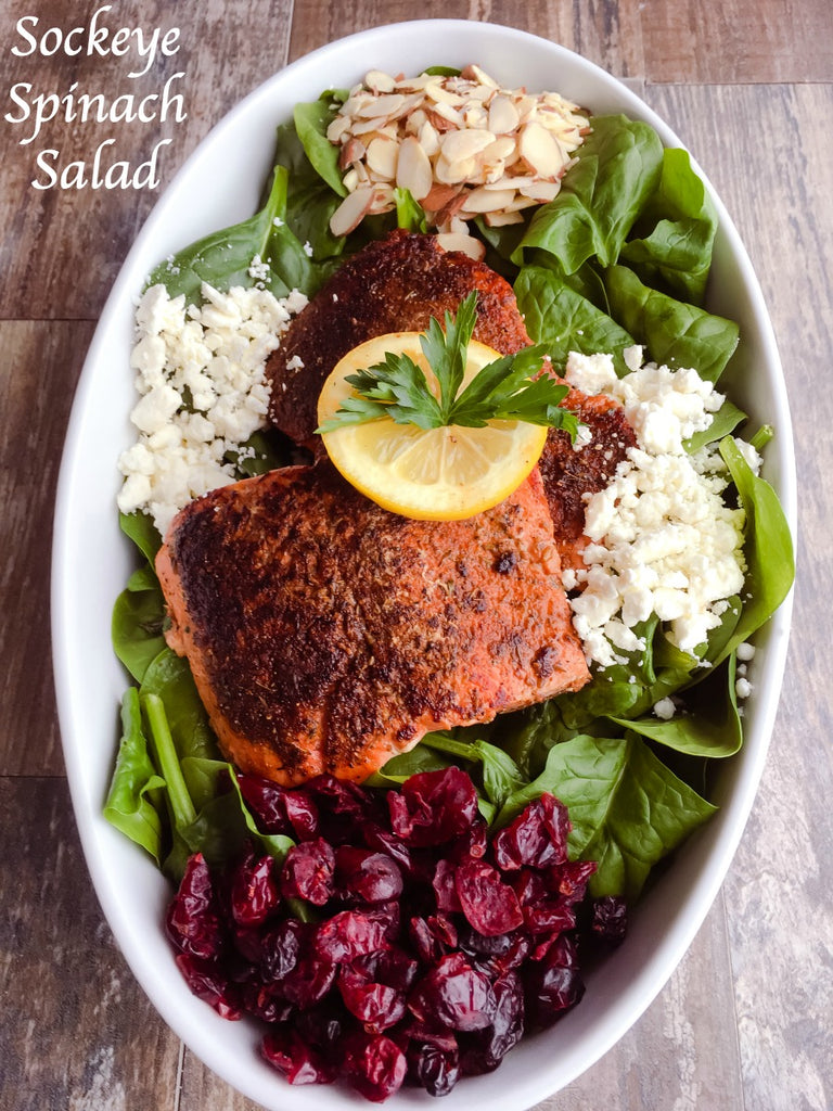 Sockeye Spinach Salad is a hearty and healthy salad with seasoned seared sockeye salmon, almonds, cranberries, and feta cheese on a crisp bed of spinach greens dressed with a tangy balsamic vinaigrette. 