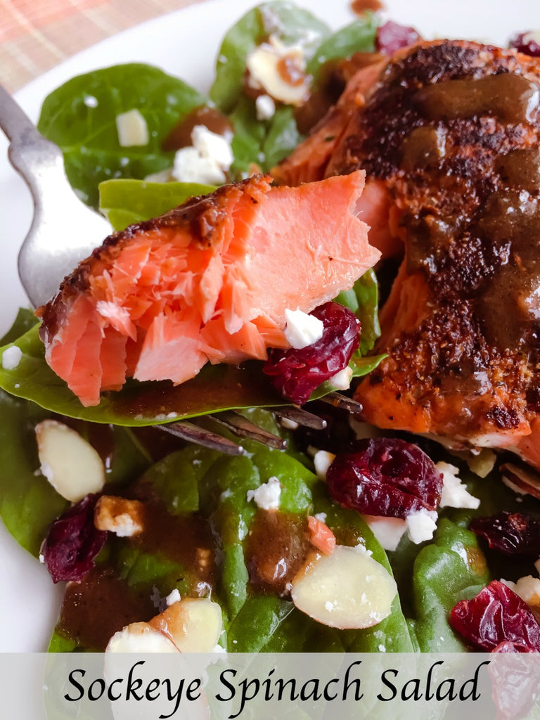 Sockeye Spinach Salad is a hearty and healthy salad with seasoned seared sockeye salmon, almonds, cranberries, and feta cheese on a crisp bed of spinach greens dressed with a tangy balsamic vinaigrette. 