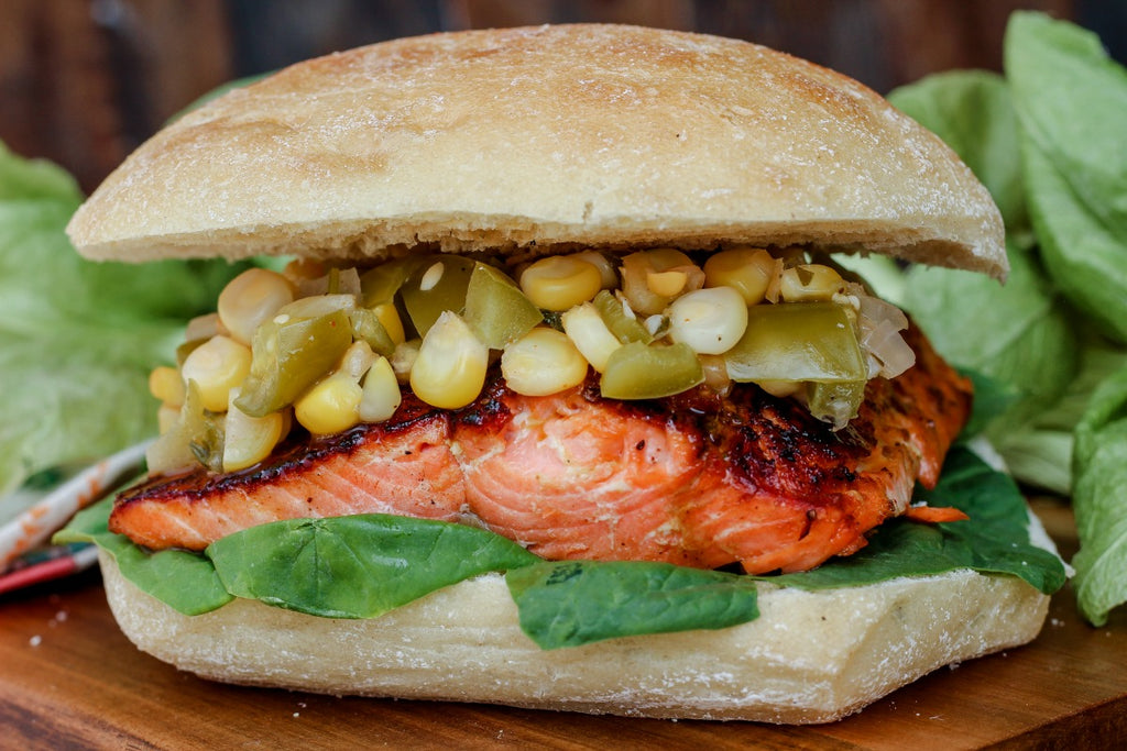 Tomatillo Corn Salmon Sandwich combines unique ingredients like a tomatillo corn relish, sustainable sockeye salmon, and Old Bay seasoning for one tasty nosh. 