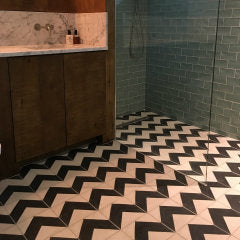 Black and white encaustic floor tiles in a chevron design