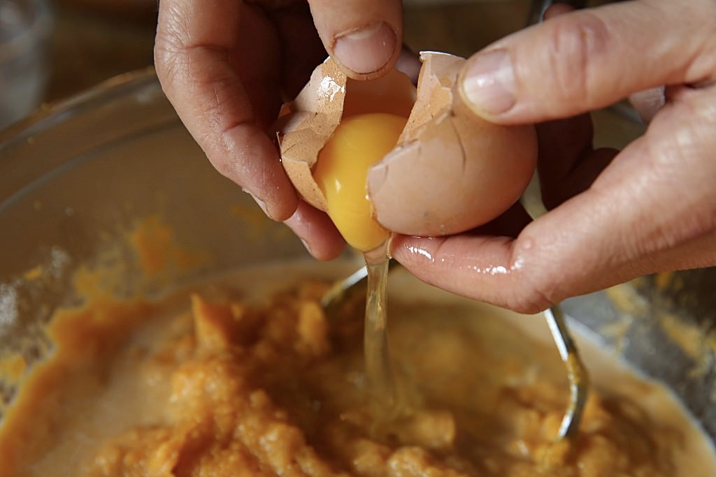 Egg poured into Sweet potatoes for casserole baked in the Fontana fired oven 