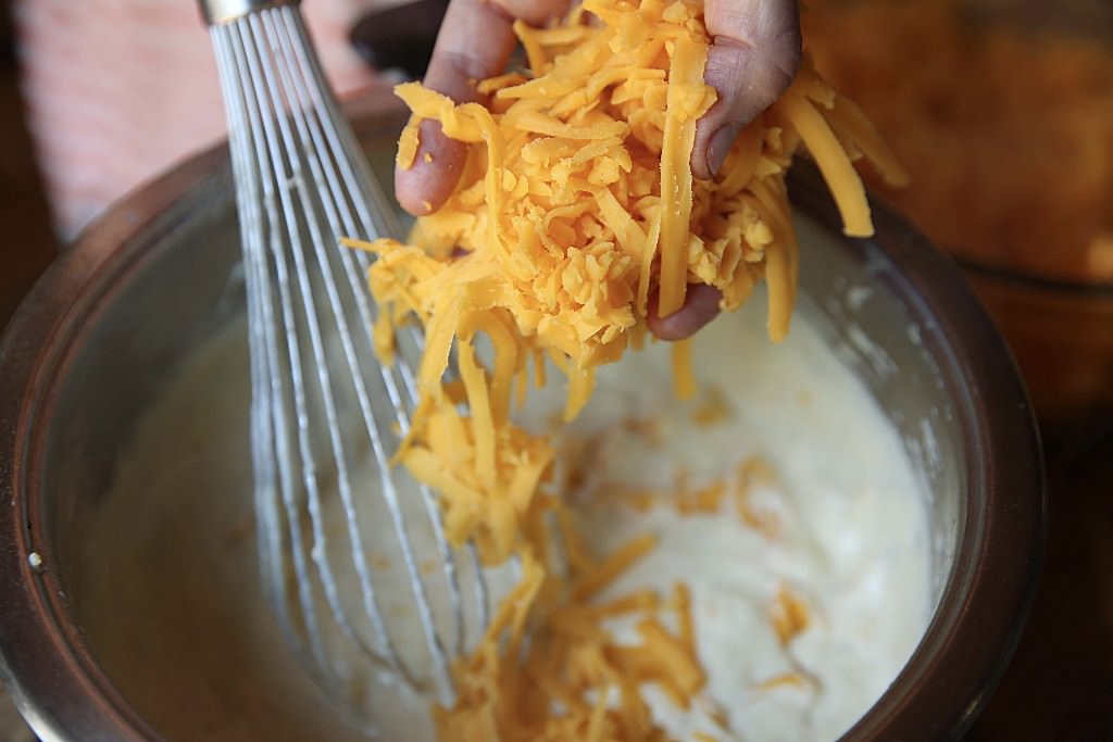 Mix cheddar cheese with bechamel for mac and cheese baked in the Fontana wood-burning oven 