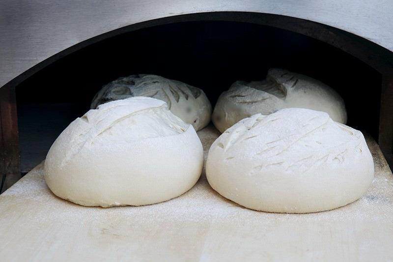 Put dough in the oven Score dough for bread baked in the Fontana wood-burning oven