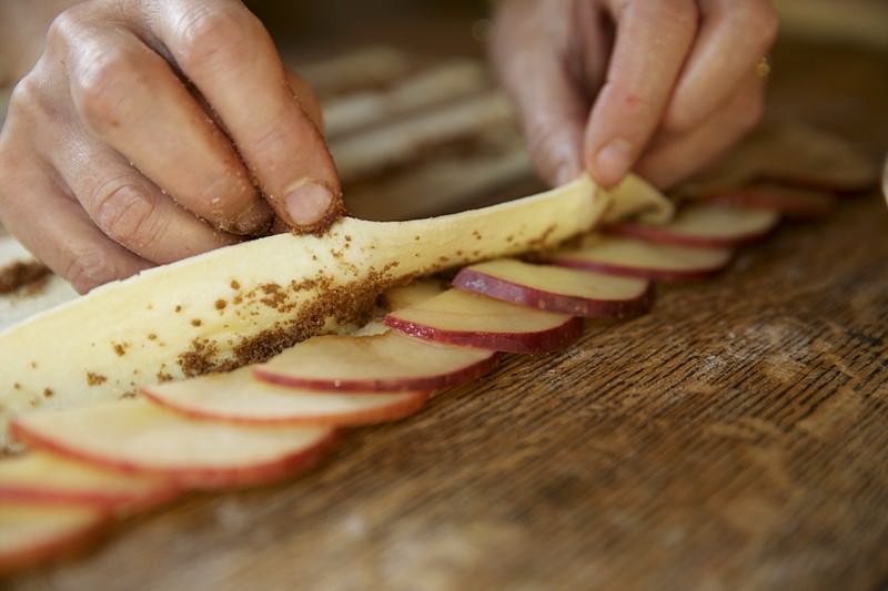 Folding puffed pastry over apples and brown sugar to put in Fontana wood-fired oven 