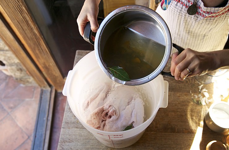 Pouring brine on turkey to be baked in Fontana brick oven 