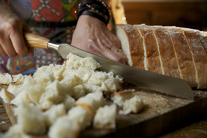 Slicing bread for stuffing to be put in turkey baked in Fontana wood-burning oven 