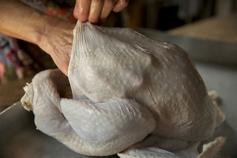 Pull skin from turkey to be baked in Fontana wood-burning oven